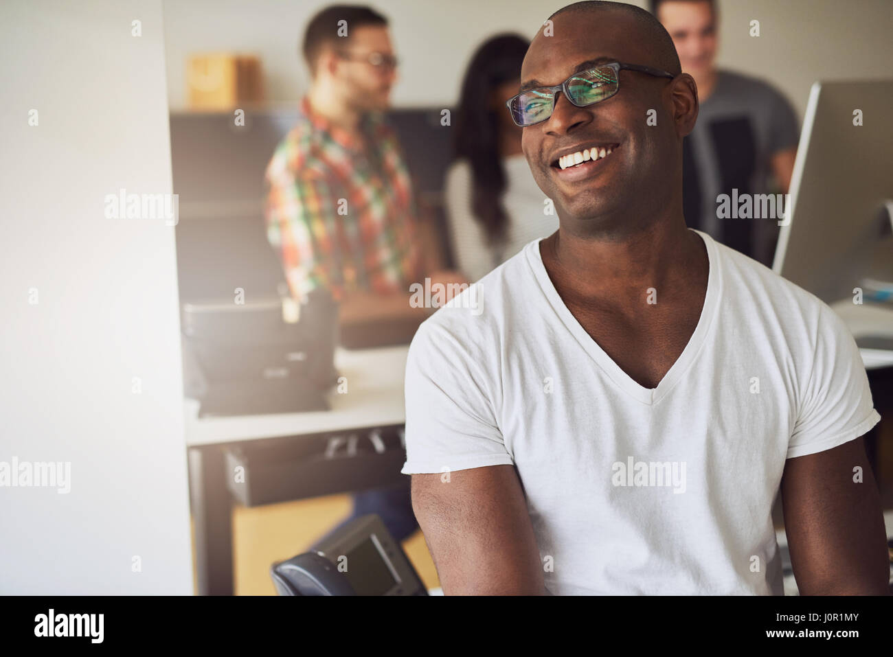 Contemporary African American businessman smiling et à l'écart dans le bureau. Banque D'Images