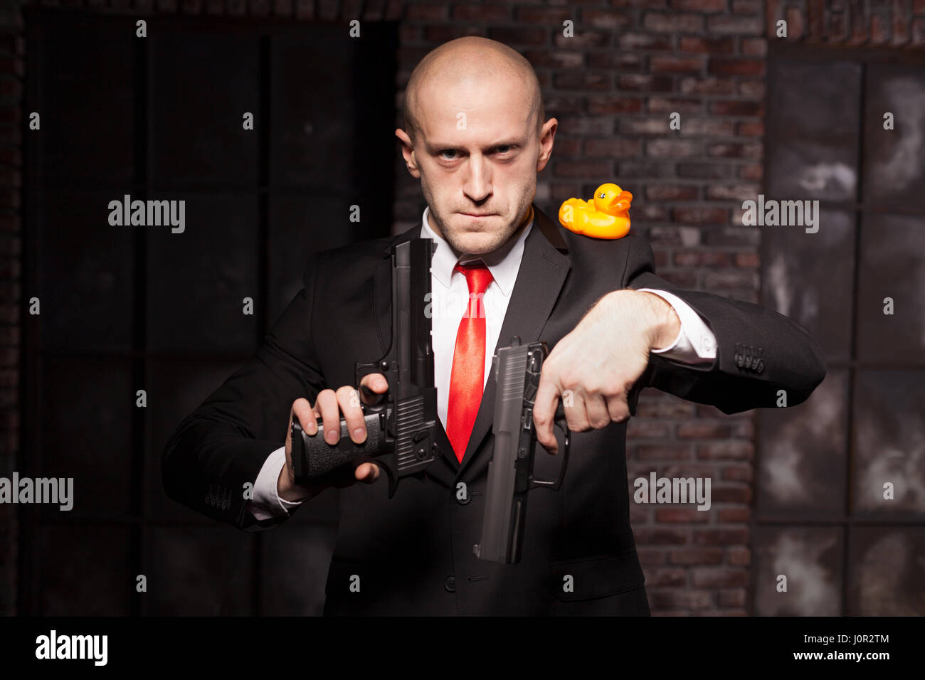Contrat en colère assassin dans costume et cravate rouge vise un pistolet  sur petit canard. Concept d'agent secret professionnel Photo Stock - Alamy