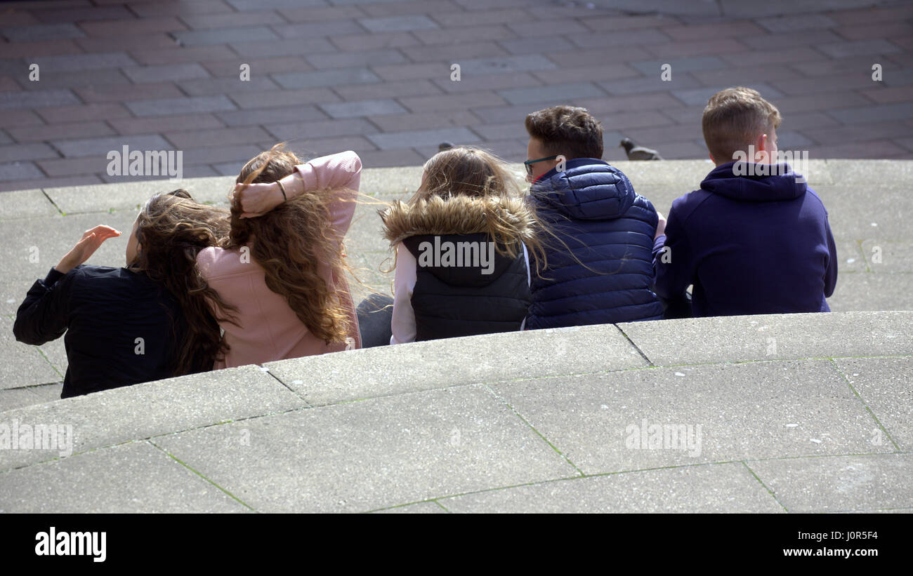 Bunch foule de jeunes adolescents ou les enfants garçons et filles de s'asseoir sur les marches de la salle de concert de Glasgow Buchanan Street et Sauchiehall Street Banque D'Images