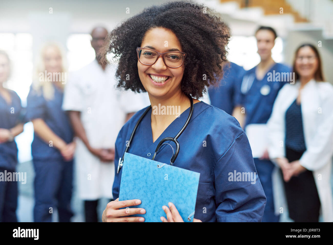 Smiling young black female doctor standing en face de l'équipe médicale à l'hôpital Banque D'Images