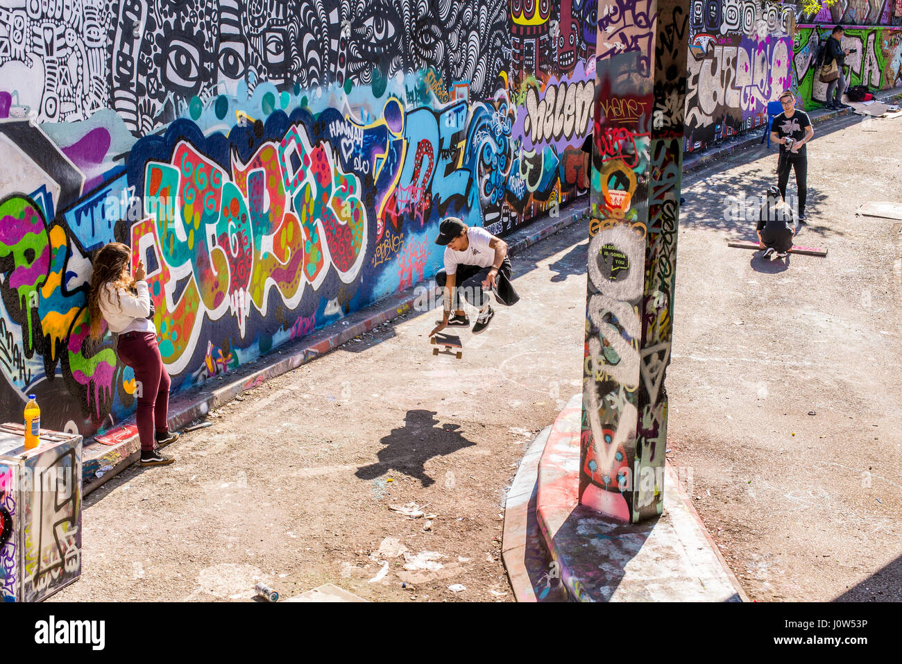 La patineuse adolescent équitation une planche à roulettes d'effectuer un ollie dans Leake Street tunnel, Londres, Royaume-Uni. Leake street aussi connu sous le nom de "Tunnel Graffiti' ou 'Banques Banque D'Images