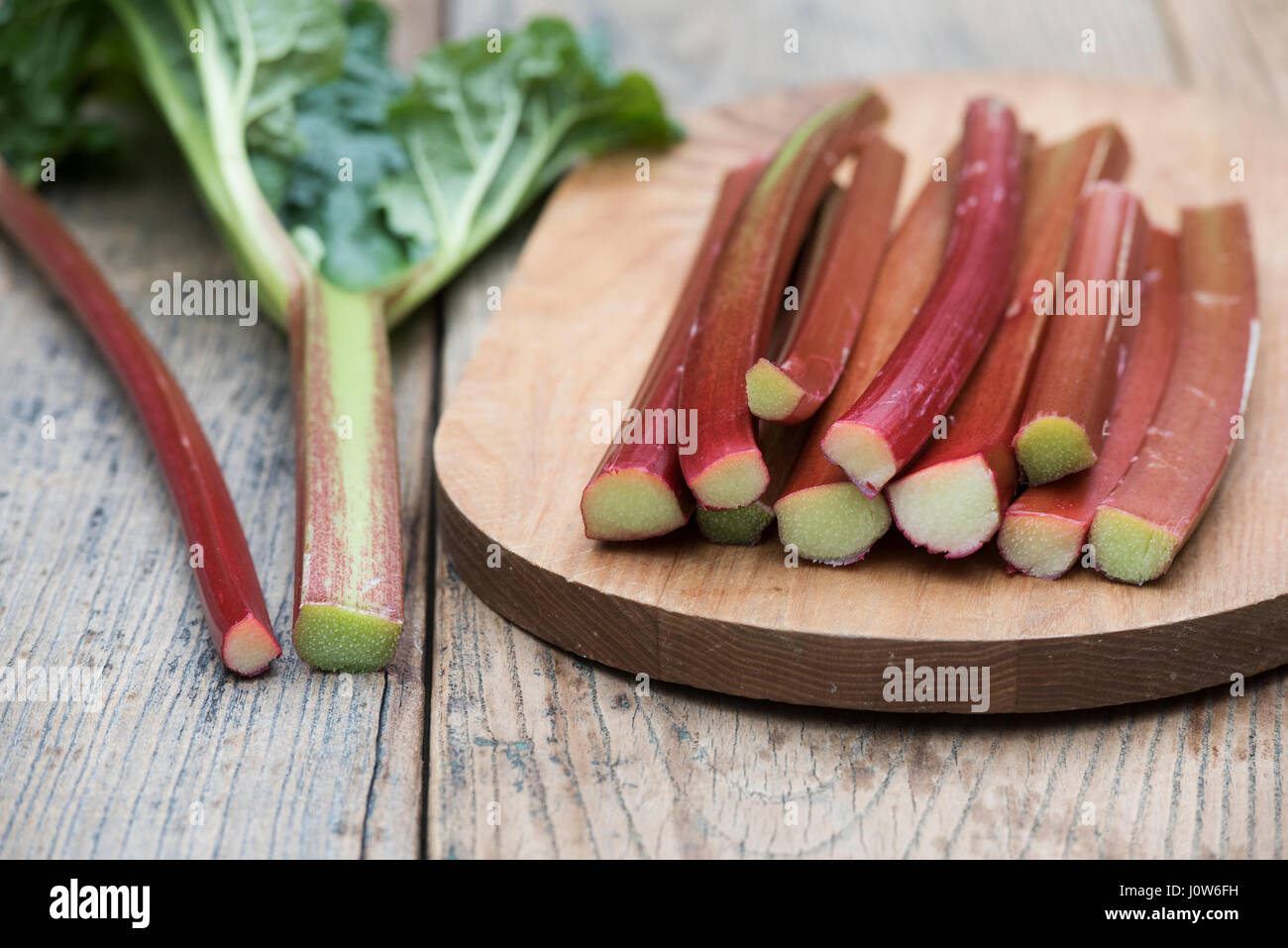 Rheum rhabarbarum. Les bâtonnets de rhubarbe récoltée sur une planche en bois Banque D'Images