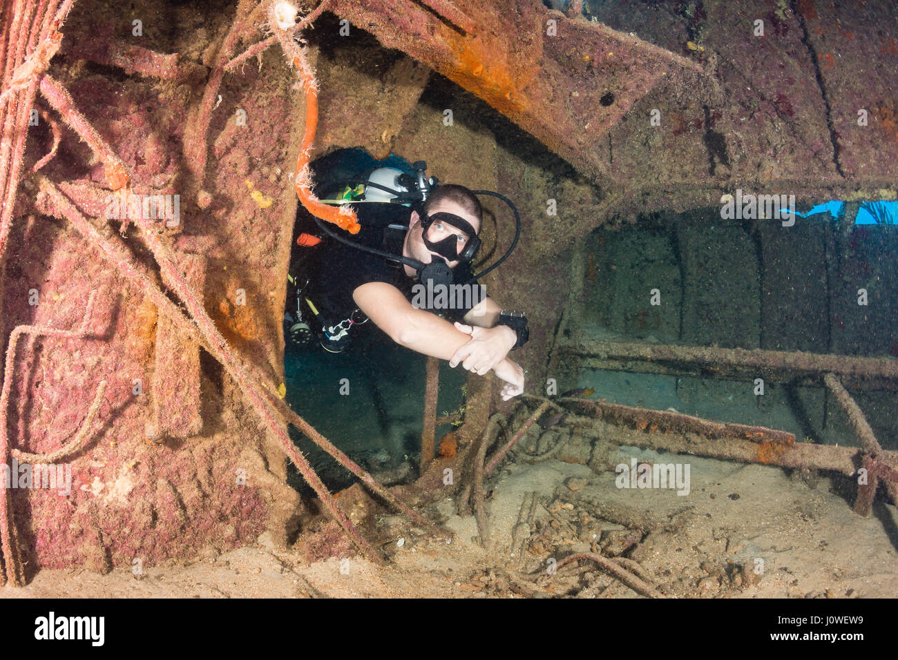 Plongée sous marine natation à travers une vieille épave sous-marine Banque D'Images