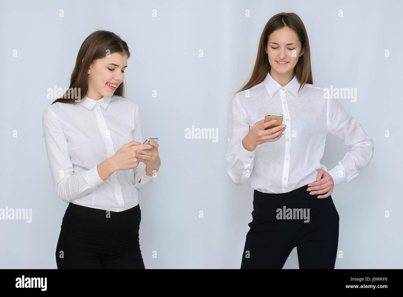 Deux jeunes filles utilisent leur mobile isolé Banque D'Images