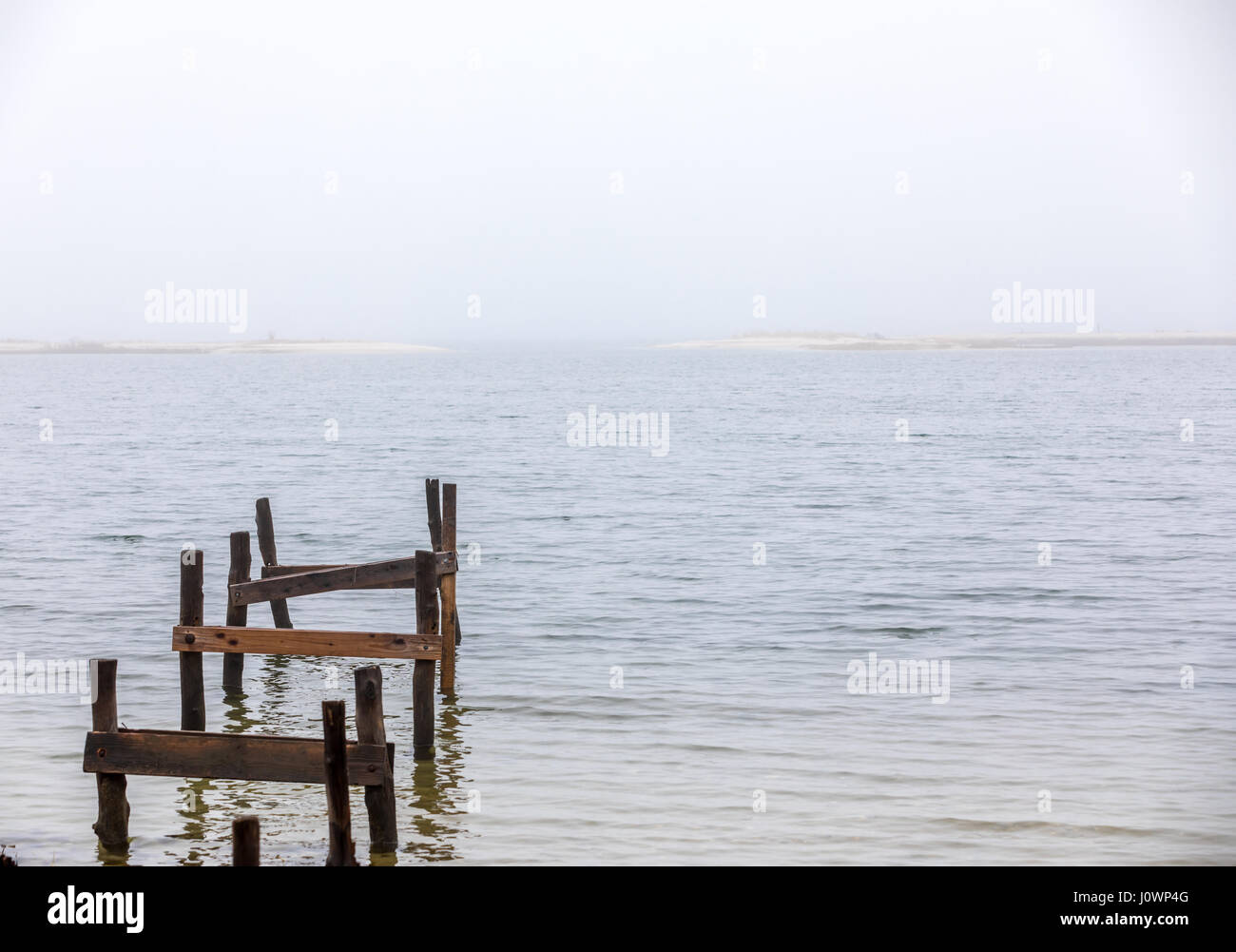 Vestiges de l'ancien quai donnant sur l'eau froide sur un jour brumeux à Hampton Bays, NY Banque D'Images