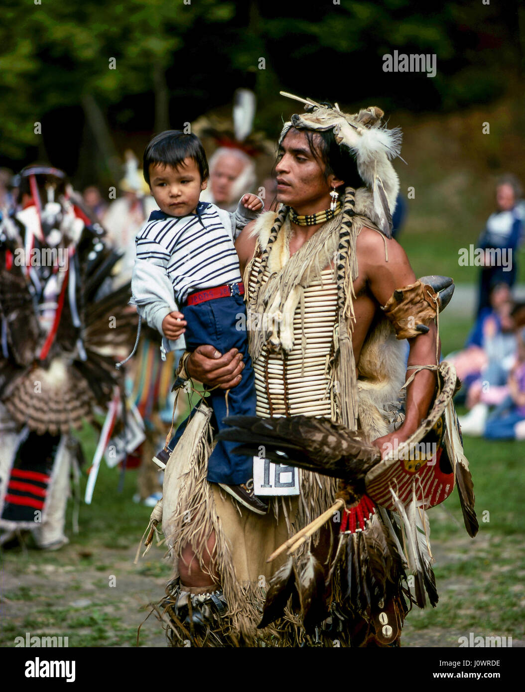 Un Native American Indian père habillés en costume tribal à danser à un powwow tenant son jeune fils. Hanover, NH, USA. Banque D'Images