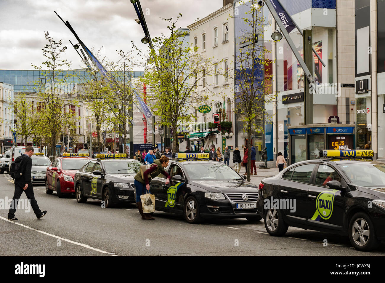 Taxis sur une station de taxis dans le centre-ville de Patrick Street, Cork, Irlande. Banque D'Images