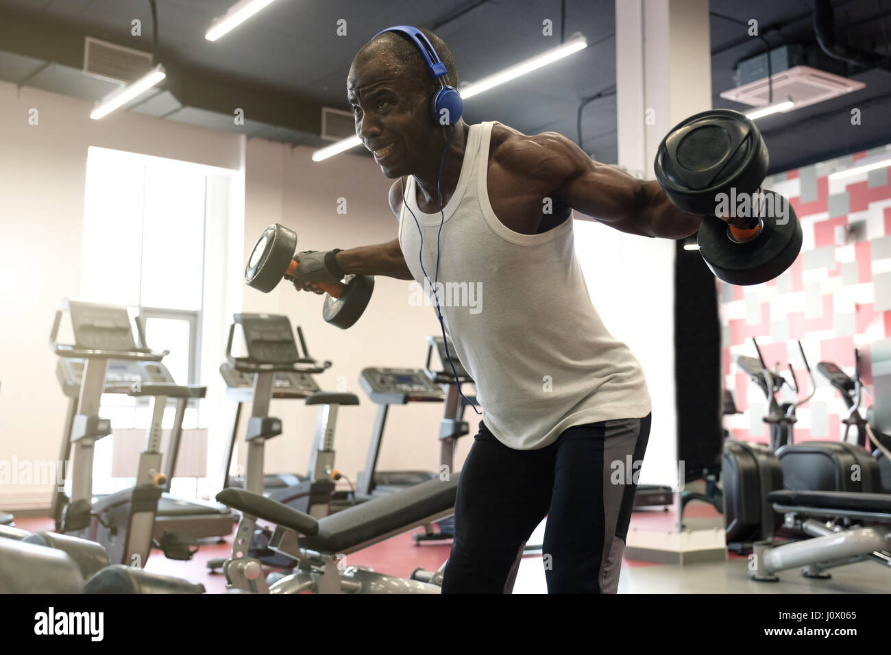 Entraînement intensif. Homme noir musclé faisant des exercices avec haltères  pour retour at gym Photo Stock - Alamy