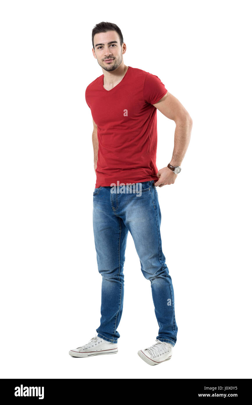 Jeune mec sympa t-shirt rouge de réglage arrière looking at camera. La pleine longueur du corps portrait studio isolated over white background. Banque D'Images