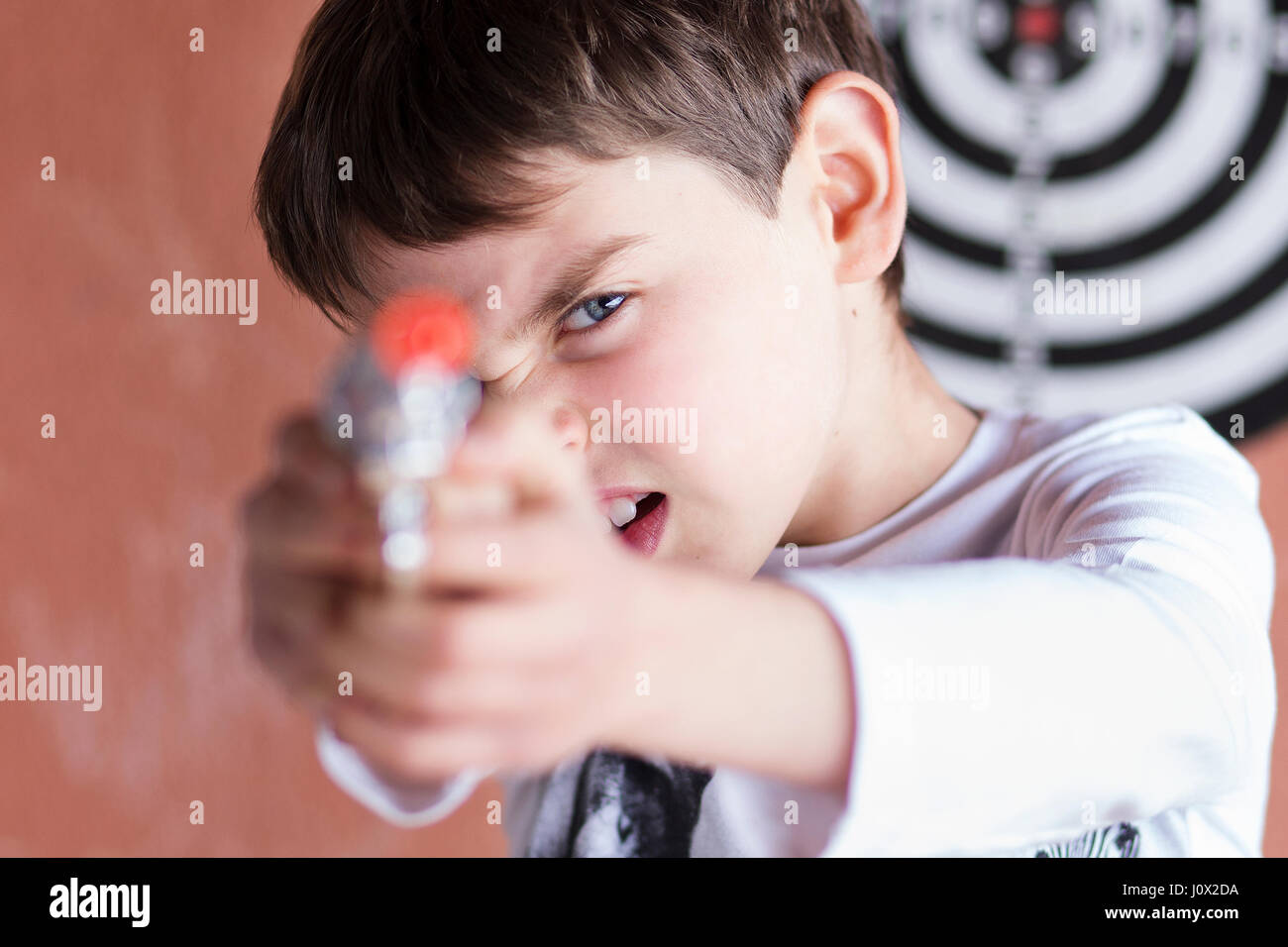 Garçon avec pour objectif de prendre un pistolet jouet Banque D'Images Garçon avec pour objectif de prendre un pistolet jouet Banque D'Images