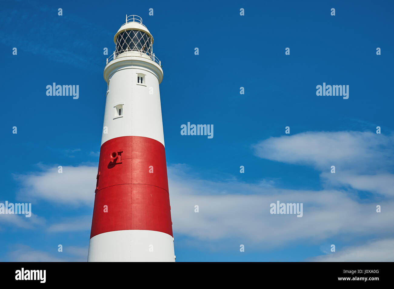 Le rouge et blanc de la tour phare de Portland, à l'extrémité sud de Portland Bill contre un ciel bleu. Banque D'Images