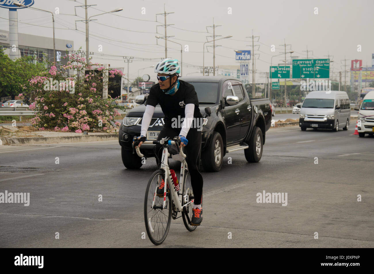 Les thaïlandais d'Asie bicyclette location dans la course sur route de la rue avec circulation road à Bangbuathong ville le 26 février 2017 dans Nonthaburi, Thaïlande Banque D'Images