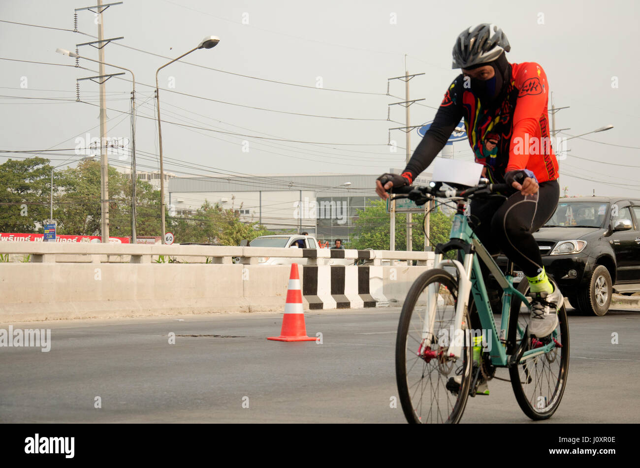 Les thaïlandais d'Asie bicyclette location dans la course sur route de la rue avec circulation road à Bangbuathong ville le 26 février 2017 dans Nonthaburi, Thaïlande Banque D'Images