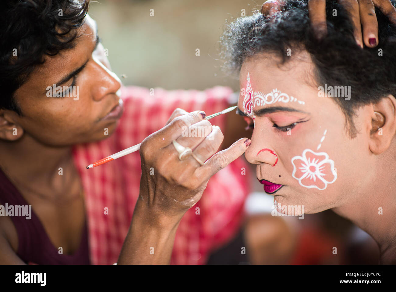 Les jeunes hommes indiens ayant son visage peint avant le festival d'Krishnadepur Bédeille, West Bengal Banque D'Images