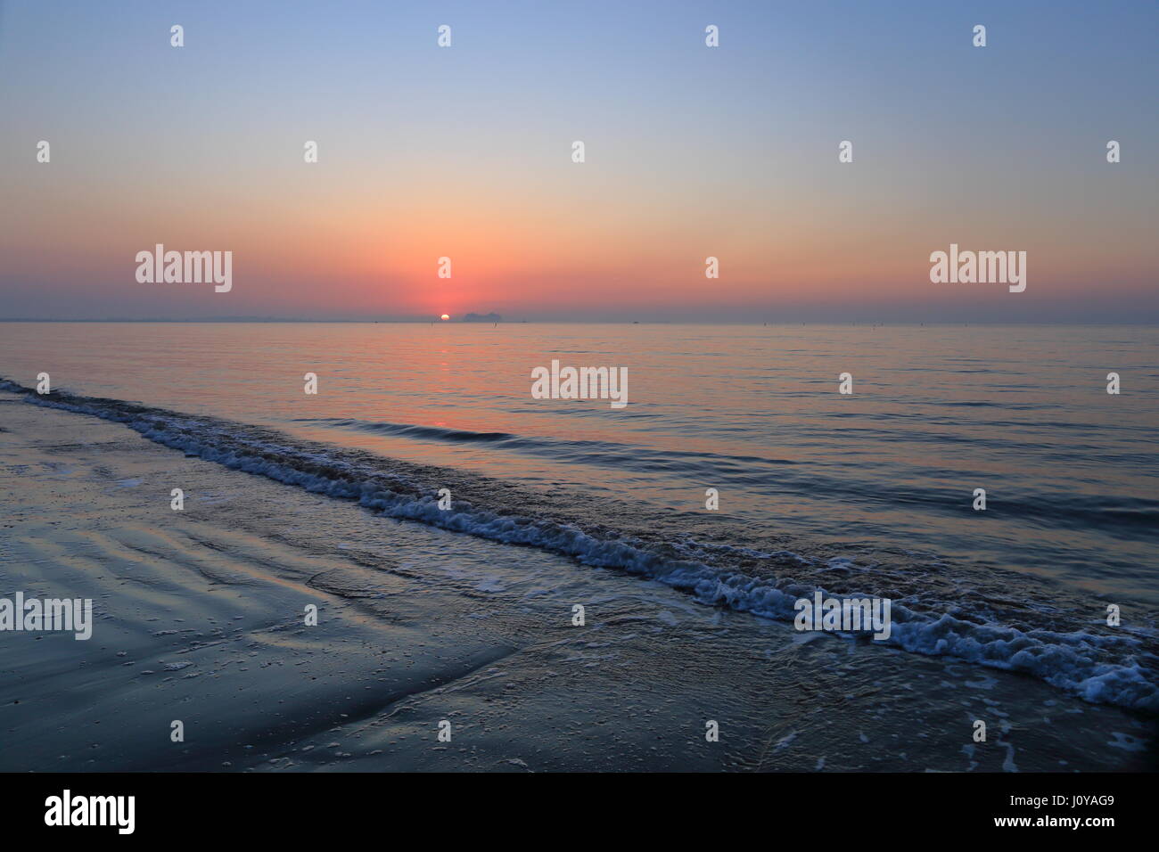 ​ Venise, Italie, un lever de soleil spectaculaire sur Lido di Venezia jetty au début d'une journée sur la côte Adriatique. Heure du lever l'ordre. Banque D'Images