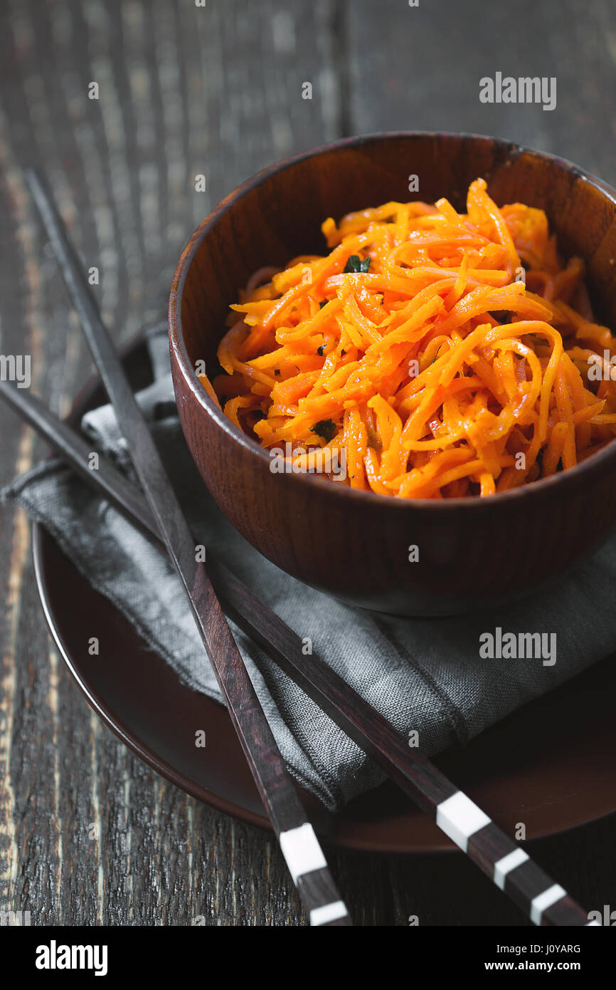 Les carottes en coréen avec des épices et des baguettes à la verticale Banque D'Images