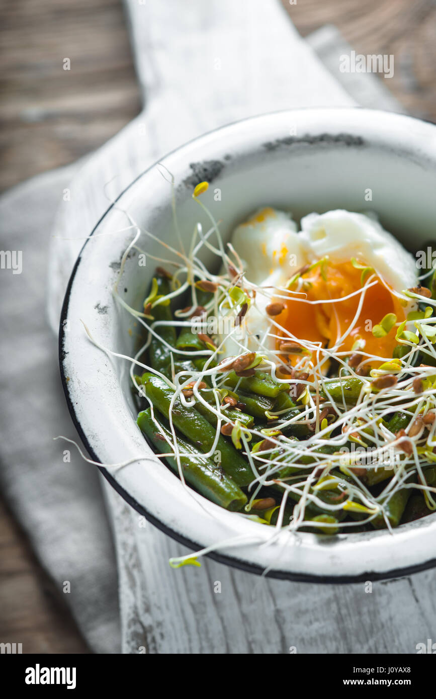 Salade avec des haricots germés, le lin et les œufs de caille dans un bol en métal à la verticale Banque D'Images