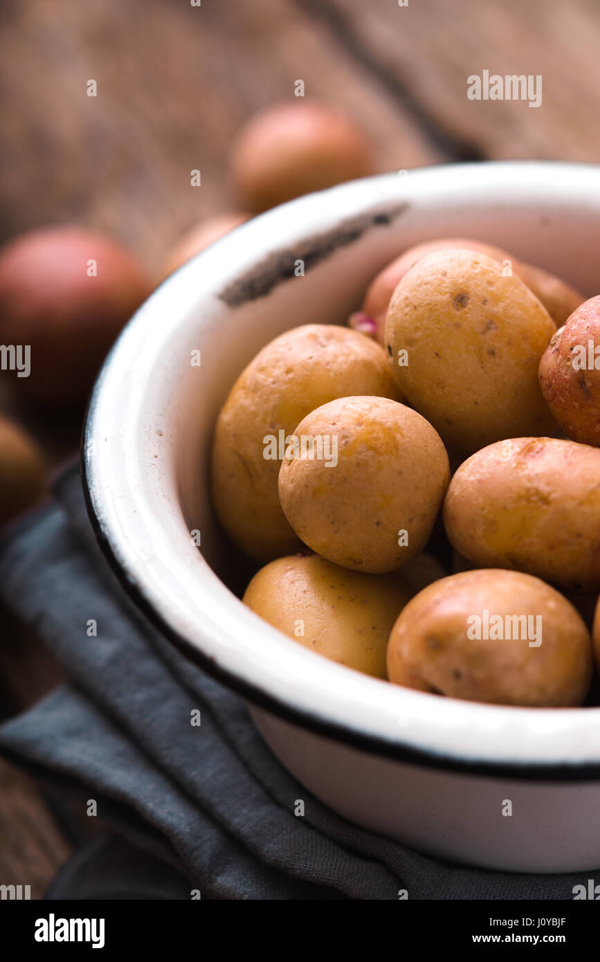 Les pommes de terre crues dans le bol en métal à la verticale Banque D'Images