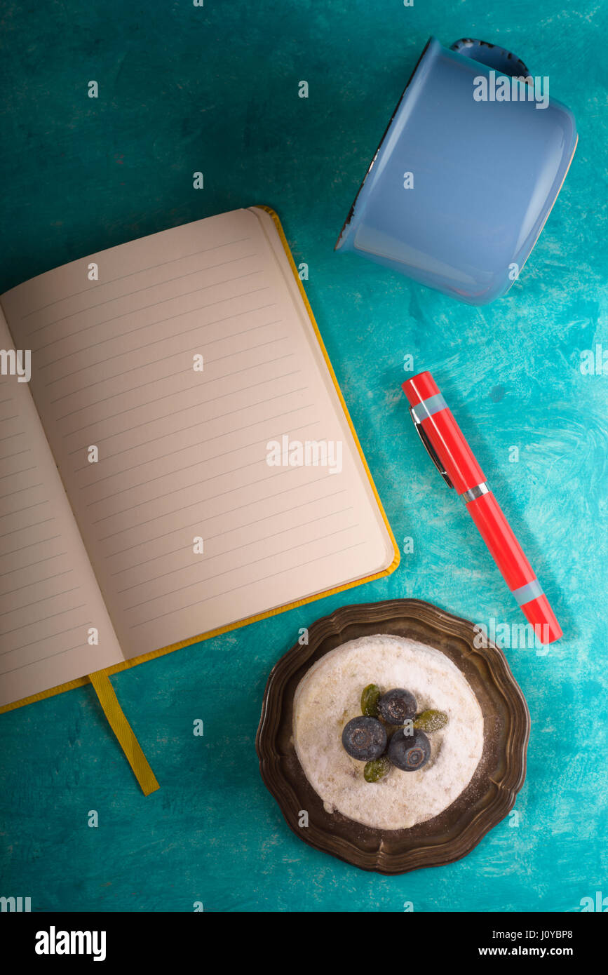 Ordinateur portable, gâteau, tasse, sur fond bleu turquoise Banque D'Images
