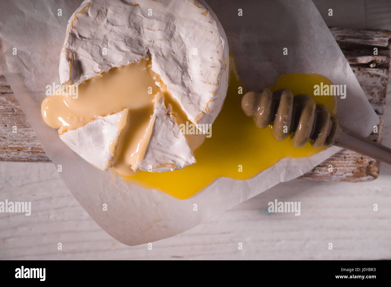 Fromage Brie, slice, miel sur parchemin et sur un support Banque D'Images