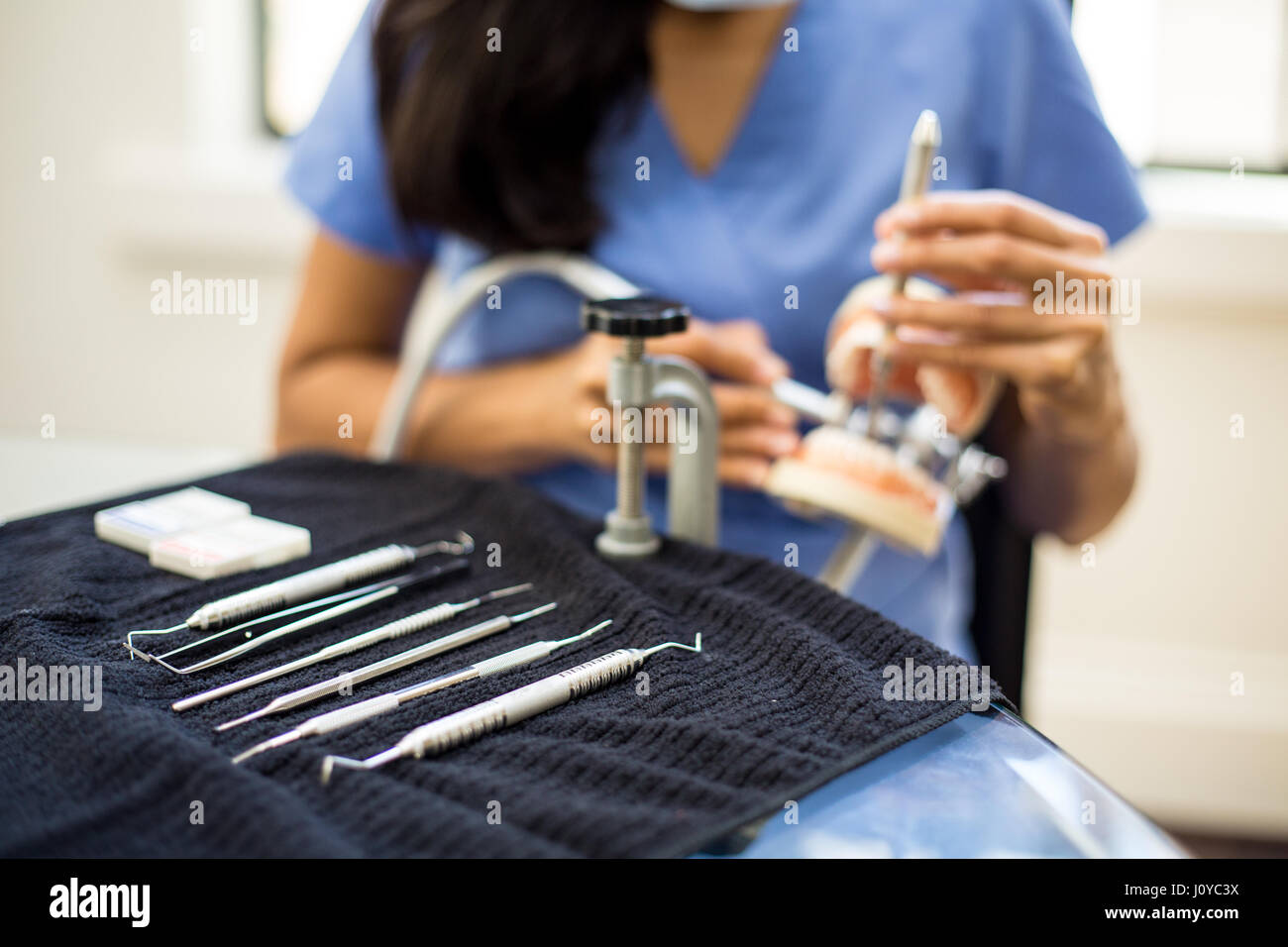 Closeup portrait, jeune étudiant professionnel oral pratique dentaire sur les dents en plastique, cire typodont monté sur table. Cavité de forage prepar Banque D'Images