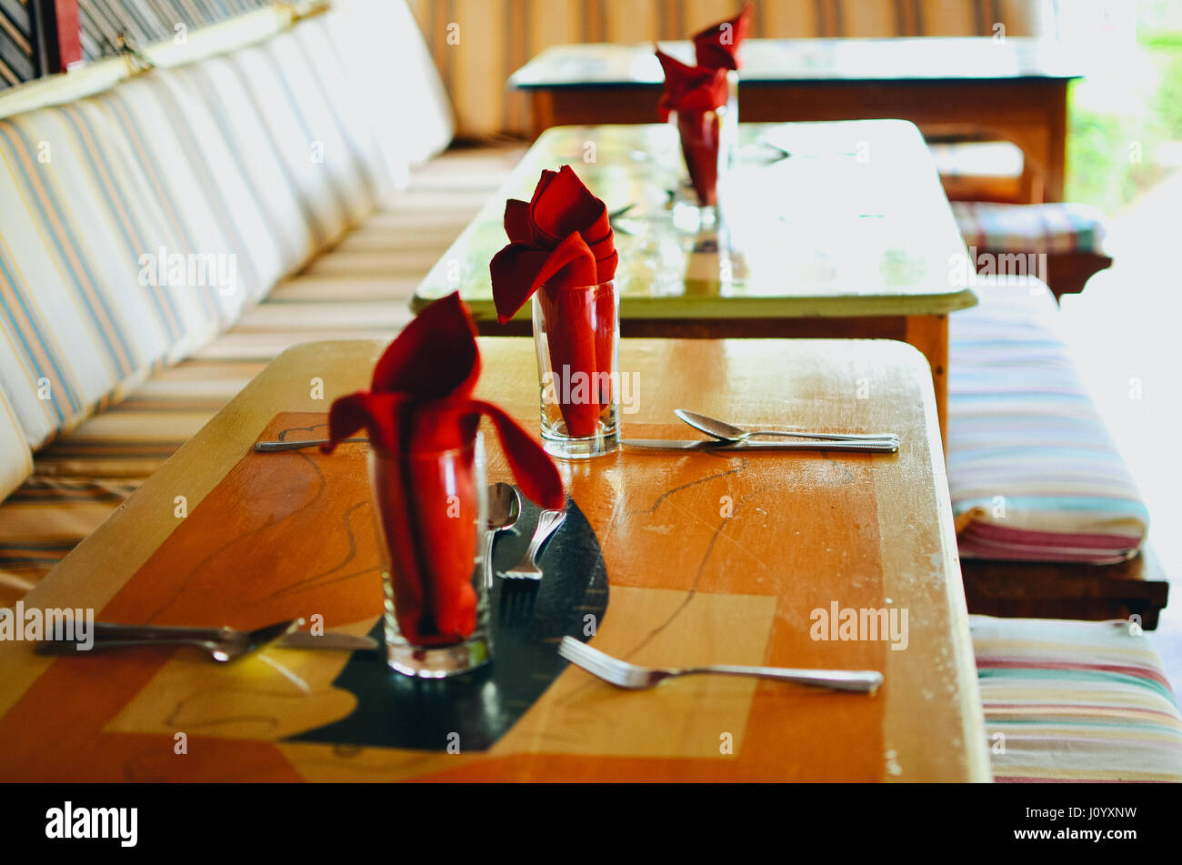 Serviettes de table rouge à l'intérieur d'un verre avec des fourchettes, couteaux et cuillères. Banque D'Images