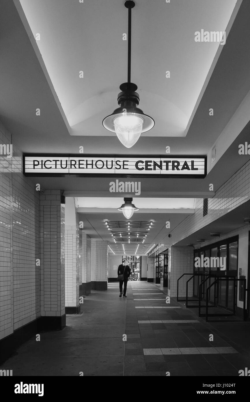 Image en noir et blanc d'un homme marchant vers le cinéma et le café central picturehouse, Londres. Banque D'Images