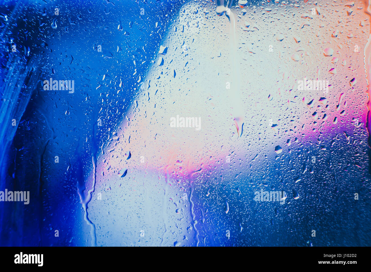 Gouttes de pluie sur un fond multicolore brouillée. Banque D'Images