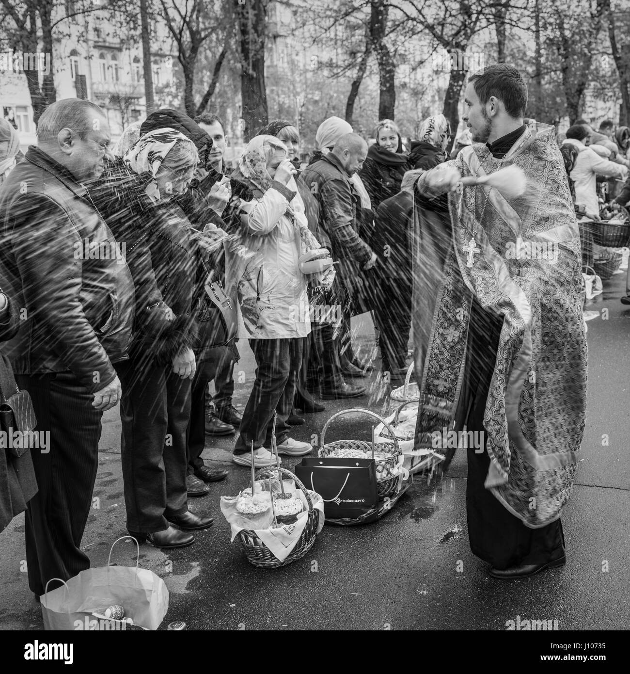 Kiev, Ukraine - 16 Avril 2017 : Prêtre bénissant les gens heureux au cours de la cérémonie du dimanche de Pâques à l'extérieur de la cathédrale St Vladimir à Kiev, Ukraine Banque D'Images
