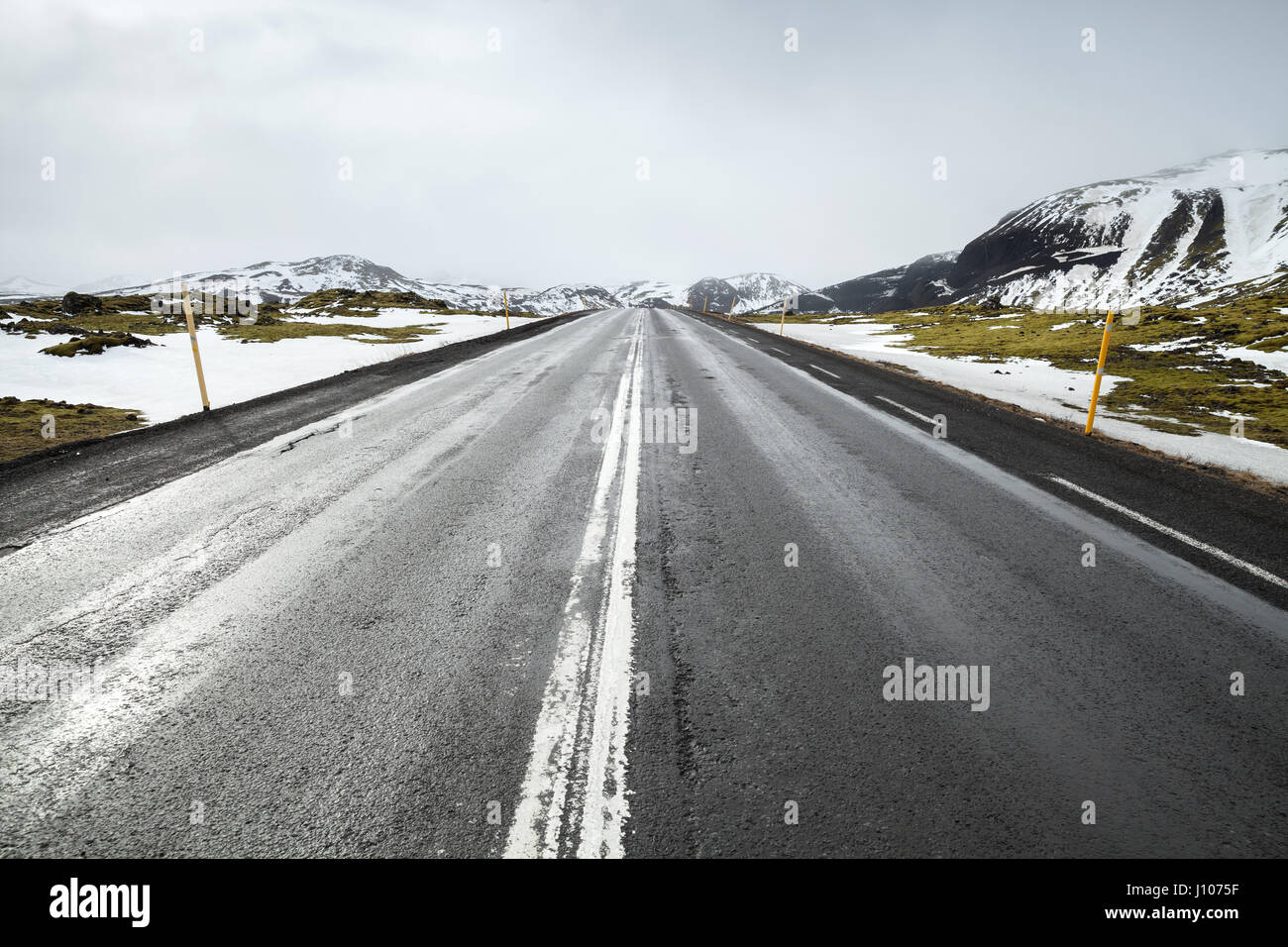 Route islandaise, perspetive paysage rural avec des montagnes enneigées à l'horizon Banque D'Images