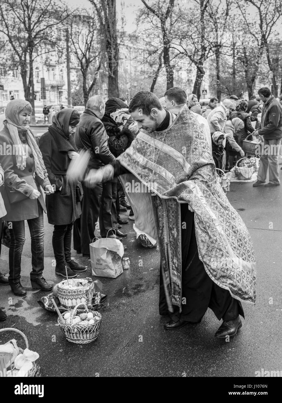 Kiev, Ukraine - 16 Avril 2017 : Prêtre bénissant les gens heureux au cours de la cérémonie du dimanche de Pâques à l'extérieur de la cathédrale St Vladimir à Kiev, Ukraine Banque D'Images