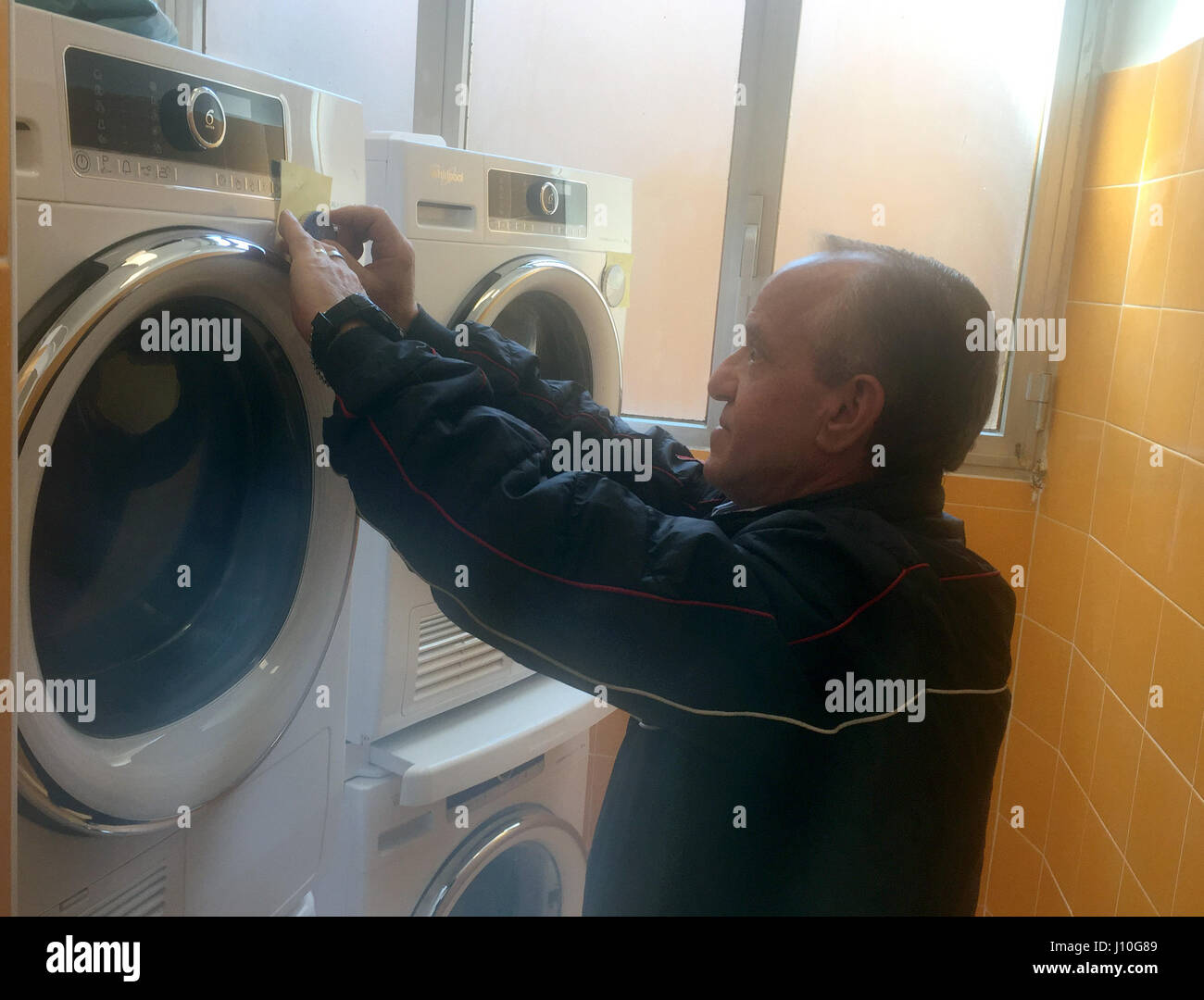 Un homme utilise une des six machines à laver dans un salon parrainé par le Pape François à Rome, Italie, 11 Apirl 2017. Le salon est conçu pour être utilisé par la ville, l'itinérance. Photo : Annette Reuther/dpa Banque D'Images