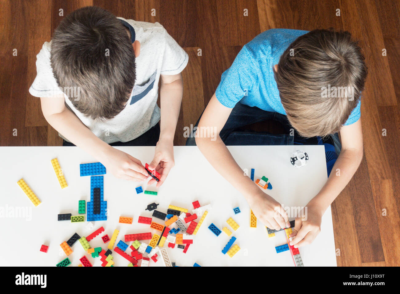 Les enfants jouent avec des briques de construction en plastique coloré Banque D'Images