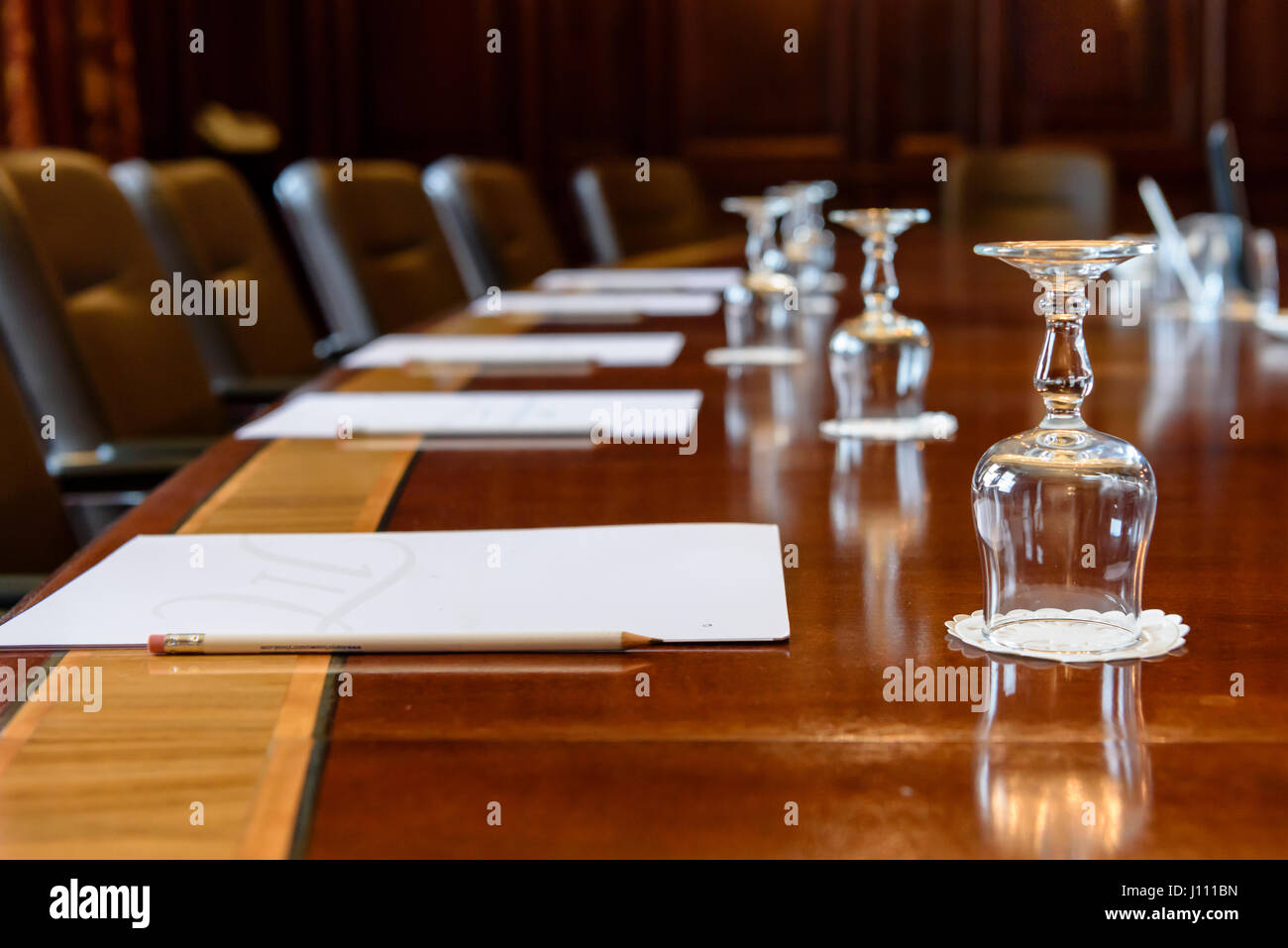 Grande table en bois dans une salle du conseil avec des lambris, mis en place à une réunion Banque D'Images