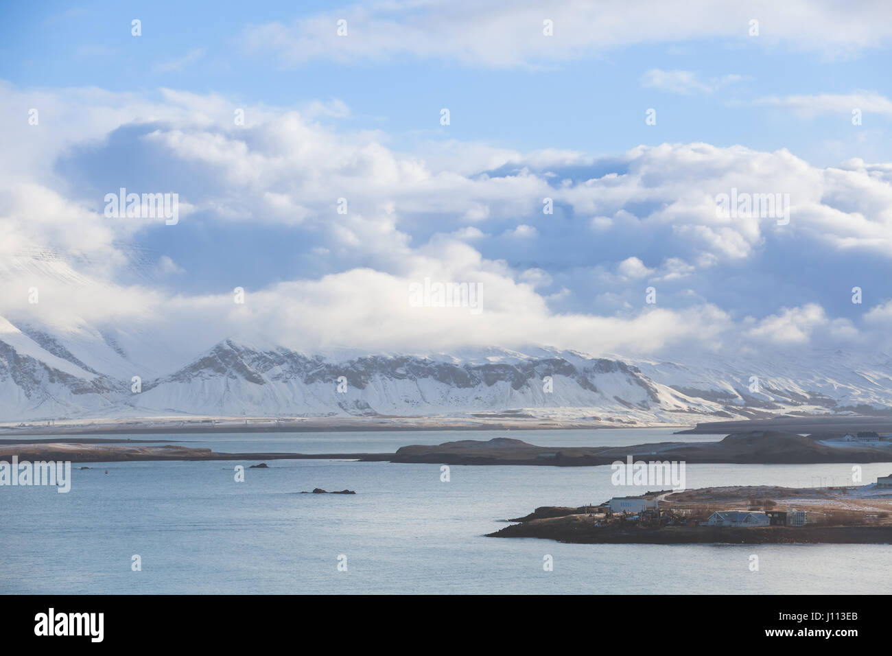 Paysage islandais côtières avec montagnes enneigées sous ciel nuageux. Baie de Reykjavik, Islande Banque D'Images