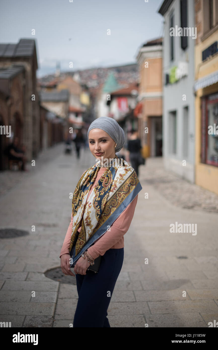 Femme portant un foulard debout dans la rue Banque D'Images