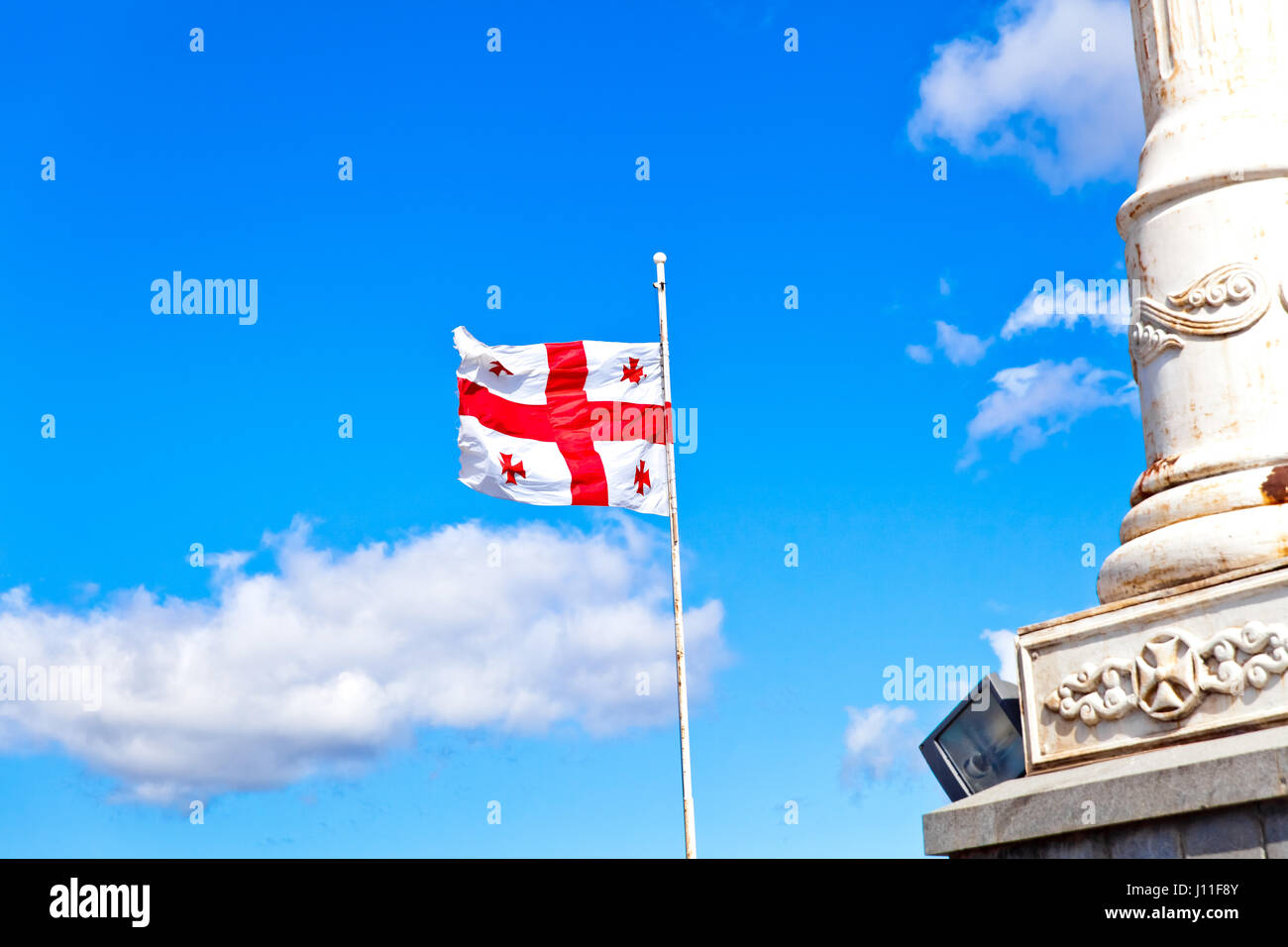 De brandir le drapeau de la Géorgie dans le ciel bleu Banque D'Images