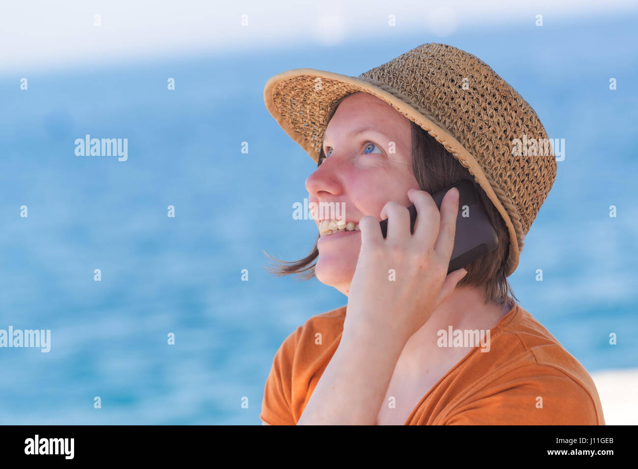 Belle hot caucasian woman wearing straw hat élégant est à l'aide de téléphone mobile sur station des vacances locations Banque D'Images