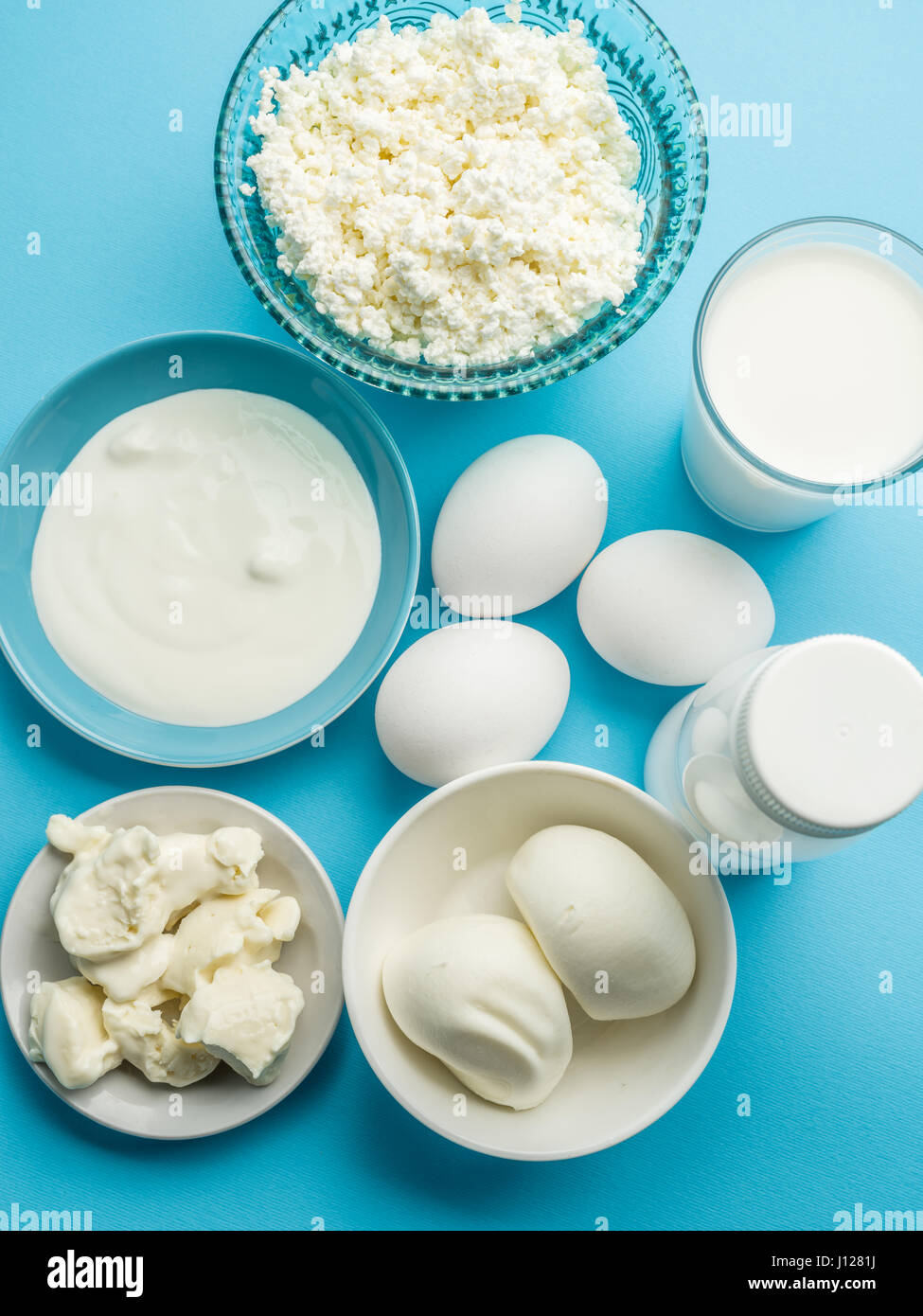 Produits de protéines : fromage, crème, lait, oeufs sur le fond bleu. Vue d'en haut. Banque D'Images