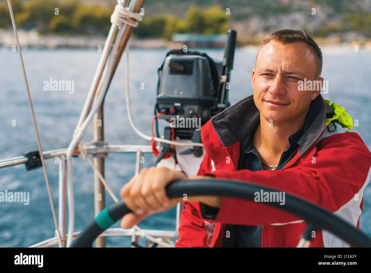 Marin heureux à la barre de son yacht. Banque D'Images