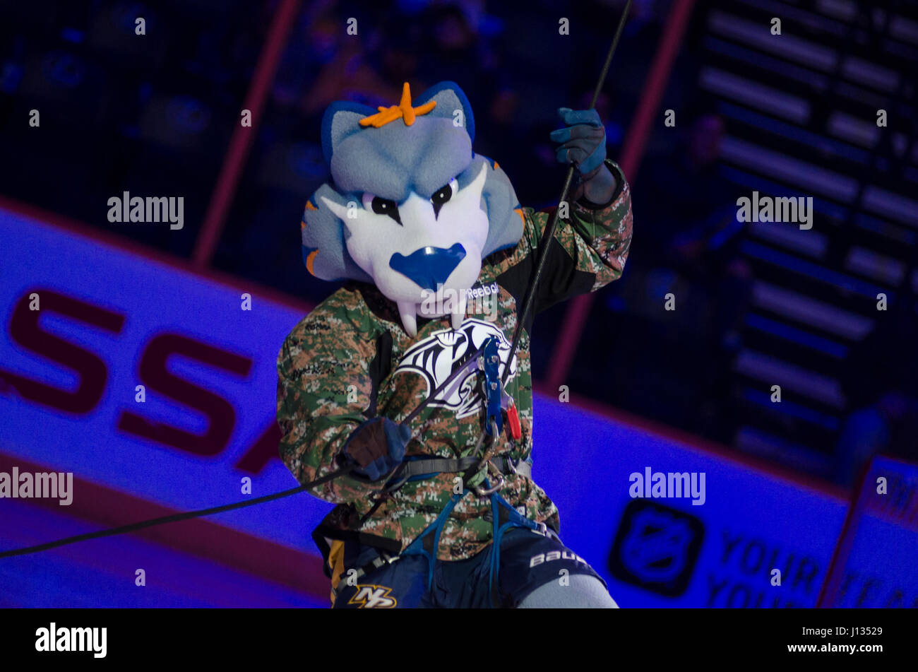 Portant une chemise de camouflage, GNASH, la mascotte des Nashville  Predators, descendu en rappel depuis le haut de la Bridgestone Arena avant  le jeu 25 mars 2017, dans le cadre de la
