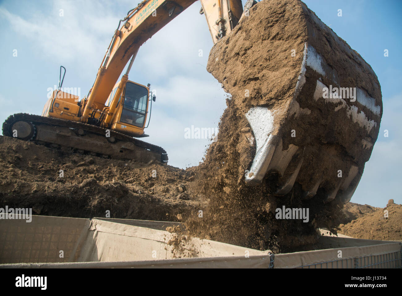 Un entrepreneur à l'aide d'une excavatrice remplit le bunker HESCO barrières défensives pour être utilisé comme une barrière de protection avec de la terre pour l'installation de la motionnaire Theissen Armor cible (MAT), 6 avril 2017. Le système de ciblage peut déplacer une silhouette réservoir cible à une vitesse de 20 milles à l'heure pour jusqu'à 340 mètres. Le système sera utilisé pour les exercices de tir réel avec des soldats américains et des forces terrestres de la Roumanie à l'occasion des prochains exercices. (U.S. Photo de l'armée par Martin Greeson) Banque D'Images