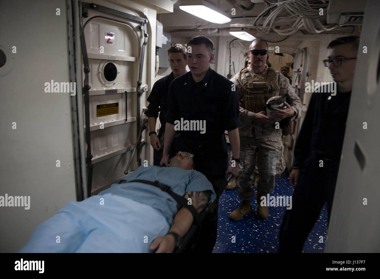 Hôpital Corpsmen affecté à la 24e Marine Expeditionary Unit (MEU) et quai de transport amphibie USS Mesa Verde (LPD 19) escort un acteur blessé sur une civière à la salle d'opération à bord du navire pour être traités au cours d'un exercice d'évacuation blessés le 7 avril 2017. La 24e MEU est en cours avec le groupe amphibie Bataan à l'appui d'opérations de sécurité maritime et les efforts de coopération en matière de sécurité dans le théâtre de la 6ème flotte zone d'opérations. (U.S. Marine Corps photo prise par le sergent d'artillerie. Adaecus G. Brooks) Banque D'Images