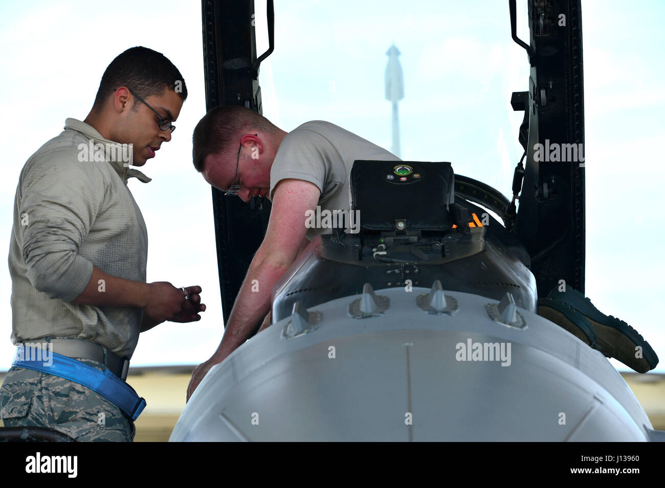 Les cadres supérieurs de l'US Air Force Airman Edwin Ayala-Yeyes, gauche, et d'un membre de la 1re classe Jonathan Benton, droite, 20e Escadron de maintenance des aéronefs et l'ingénieur électrique de compagnons, remplacer un F-16CM Fighting Falcon cabin pressostat de charge chez Shaw Air Force Base, S.C., le 10 avril 2017. Les aviateurs ont suivi une fois l'ordre technique conformité destiné à empêcher tout défaut de la part, d'assurer la sécurité des avions et pilotes. (U.S. Air Force photo par un membre de la 1re classe Christopher Maldonado) Banque D'Images