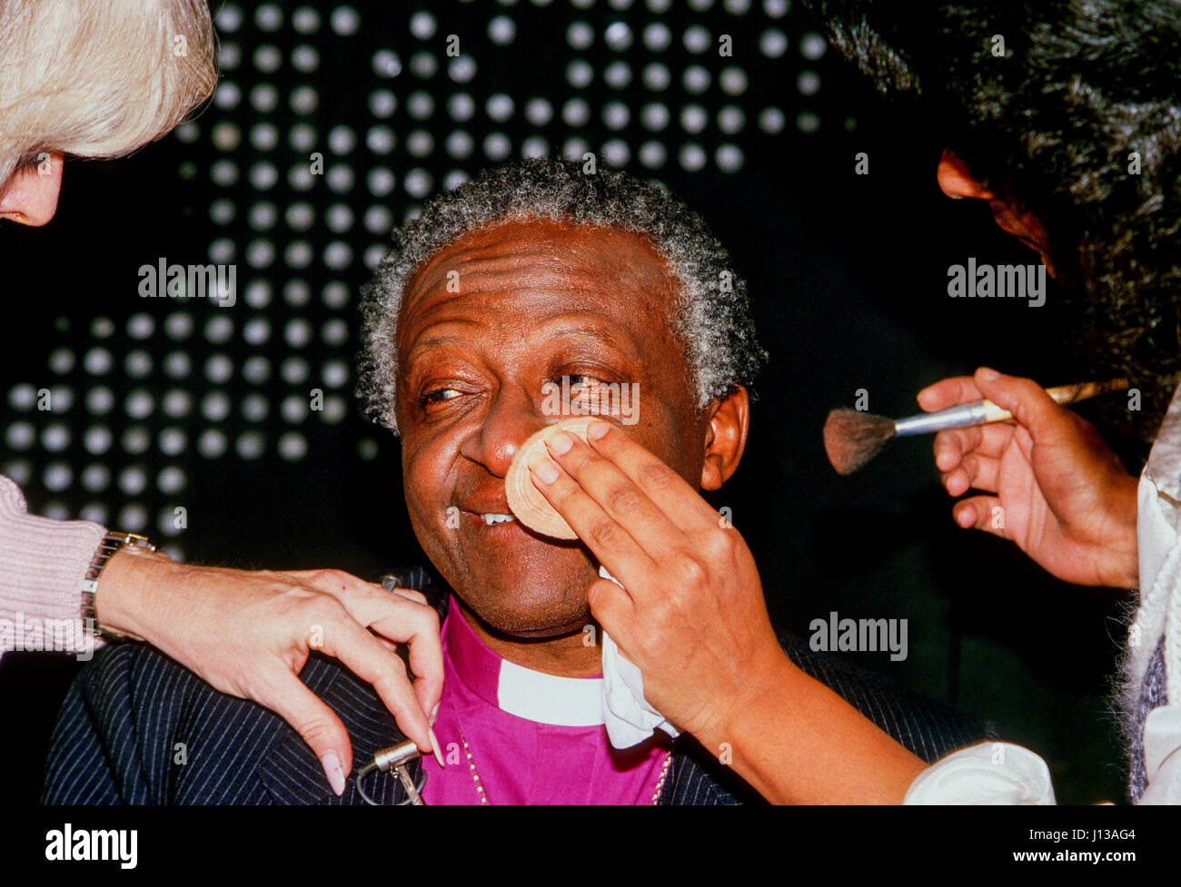 L'évêque Desmond Tutu devient un miroir appliqué à sa face avant sa première apparition sur le câble CNN News Salon "Larry King live" de Washington DC., juillet, 1985. Photo par Mark Reinstein Banque D'Images