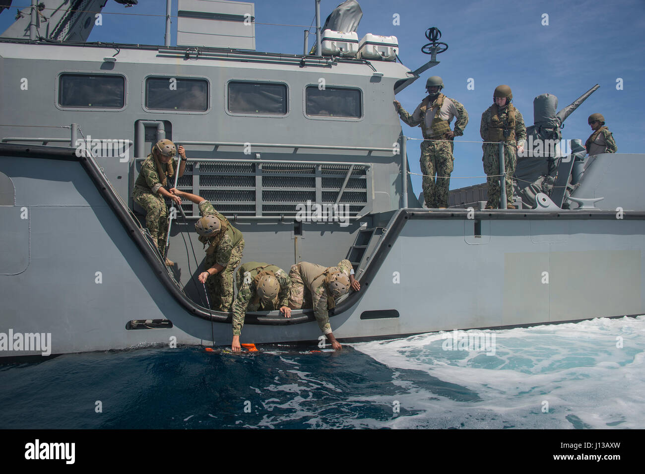Les marins affectés à l'unité mobile de destruction des engins explosifs (EODMU) et 5 Escadron fluviales côtières (CRS) 3 la libération d'un véhicule sous-marin sans pilote sur le côté d'un MK VI le bateau de patrouille au large de Guam le 12 avril 2017. EODMU 5 et 3 CRS coordonnent ensemble pour utiliser les fonctionnalités de la MK VI le bateau de patrouille de la mission des opérations de neutralisation des explosifs dans le cadre de la planification et l'exécution du commandant de la Force 75. (U.S. Caméra de combat de la marine photo par la communication de masse 3e classe Spécialiste Alfred A. Coffield) Banque D'Images