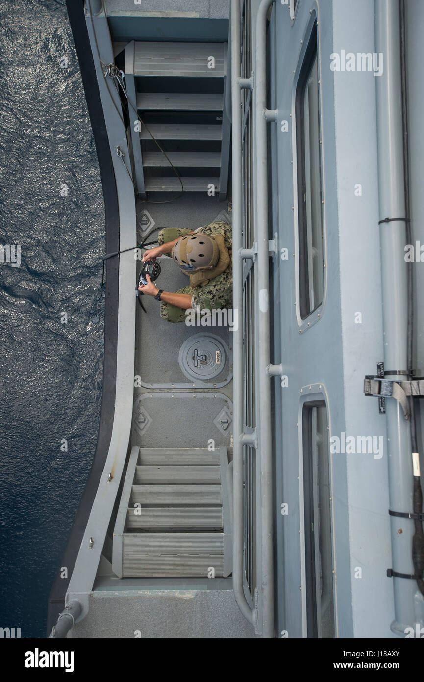 Un marin affecté à l'élimination des explosifs et munitions (unité mobile) EODMU 5 écrans un véhicule sous-marin sans pilote du côté d'une MK VI le bateau de patrouille au large de Guam le 12 avril 2017. EODMU 5 et 3 Escadron fluviales côtières sont coordonner ensemble pour utiliser les fonctionnalités de la MK VI le bateau de patrouille de la mission des opérations de neutralisation des explosifs dans le cadre de la planification et l'exécution du commandant de la Force 75. (U.S. Caméra de combat de la marine photo par la communication de masse 3e classe Spécialiste Alfred A. Coffield) Banque D'Images
