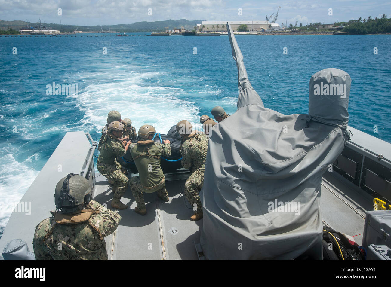 Les marins affectés à l'unité mobile de destruction des engins explosifs (EODMU) et 5 Escadron fluviales côtières (CRS) 3 Retirez un F470 la lutte contre le maraudage en caoutchouc sur un artisanat MK VI le bateau de patrouille au large de Guam le 12 avril 2017. EODMU 5 et 3 CRS coordonnent ensemble pour utiliser les fonctionnalités de la MK VI le bateau de patrouille de la mission des opérations de neutralisation des explosifs dans le cadre de la planification et l'exécution du commandant de la Force 75. (U.S. Caméra de combat de la marine photo par la communication de masse 3e classe Spécialiste Alfred A. Coffield) Banque D'Images