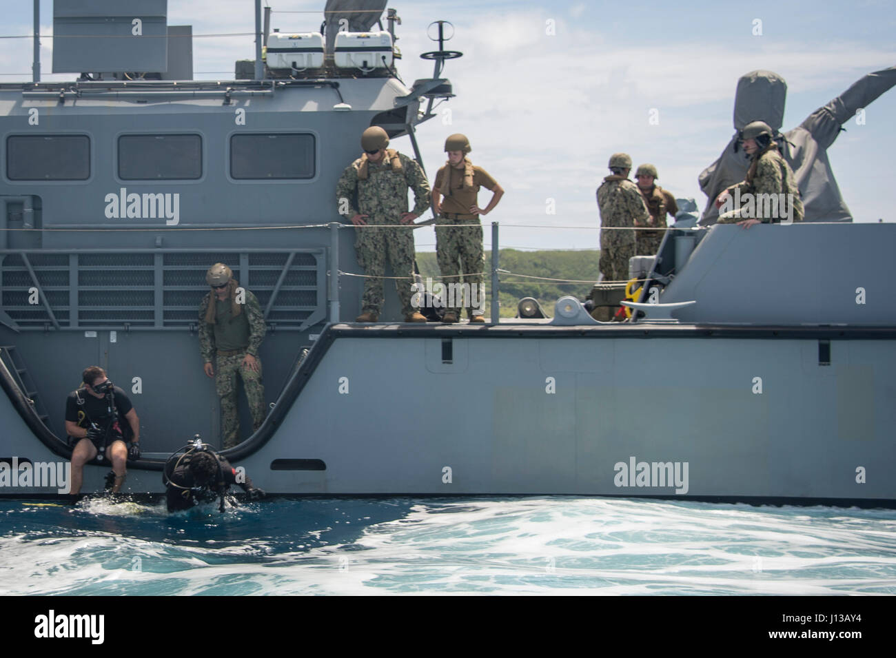 Divers affectés à l'unité mobile de destruction des engins explosifs (EODMU 5) entrent dans l'eau du côté d'une MK VI le bateau de patrouille au large de Guam le 12 avril 2017. EODMU 5 et 3 Escadron fluviales côtières sont coordonner ensemble pour utiliser les fonctionnalités de la MK VI le bateau de patrouille pour les opérations de NEDEX spécifiques dans le cadre de la planification et l'exécution du commandant de la Force 75. (U.S. Caméra de combat de la marine photo par la communication de masse 3e classe Spécialiste Alfred A. Coffield) Banque D'Images