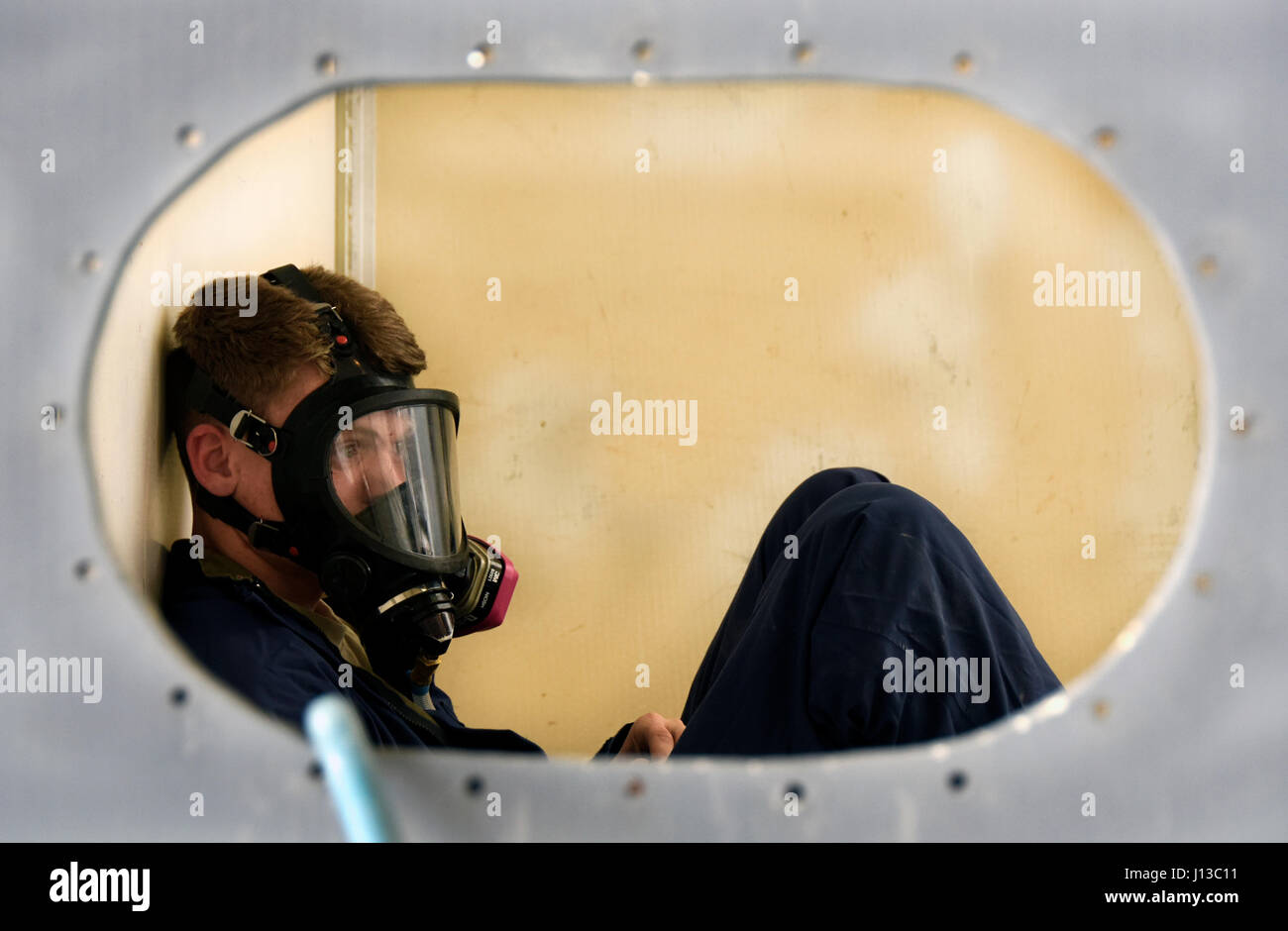 Les cadres supérieurs de l'US Air Force Airman Justin Abel, un technicien en réparation de systèmes de carburant d'aéronefs affectés au 379e Escadron de maintenance expéditionnaire, simule être piégé dans une maquette de cellule de carburant pendant un espace confiné de l'entraînement à Al Udeid Air Base, au Qatar, le 14 avril 2017. Ce type de formation est primordiale pour ces aviateurs, en raison des risques associés aux conditions qu'ils peuvent avoir à travailler. (U.S. Photo de l'Armée de l'air par la Haute Airman Cynthia A. Innocenti) Banque D'Images